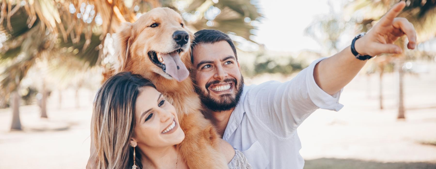 a man and woman holding a dog